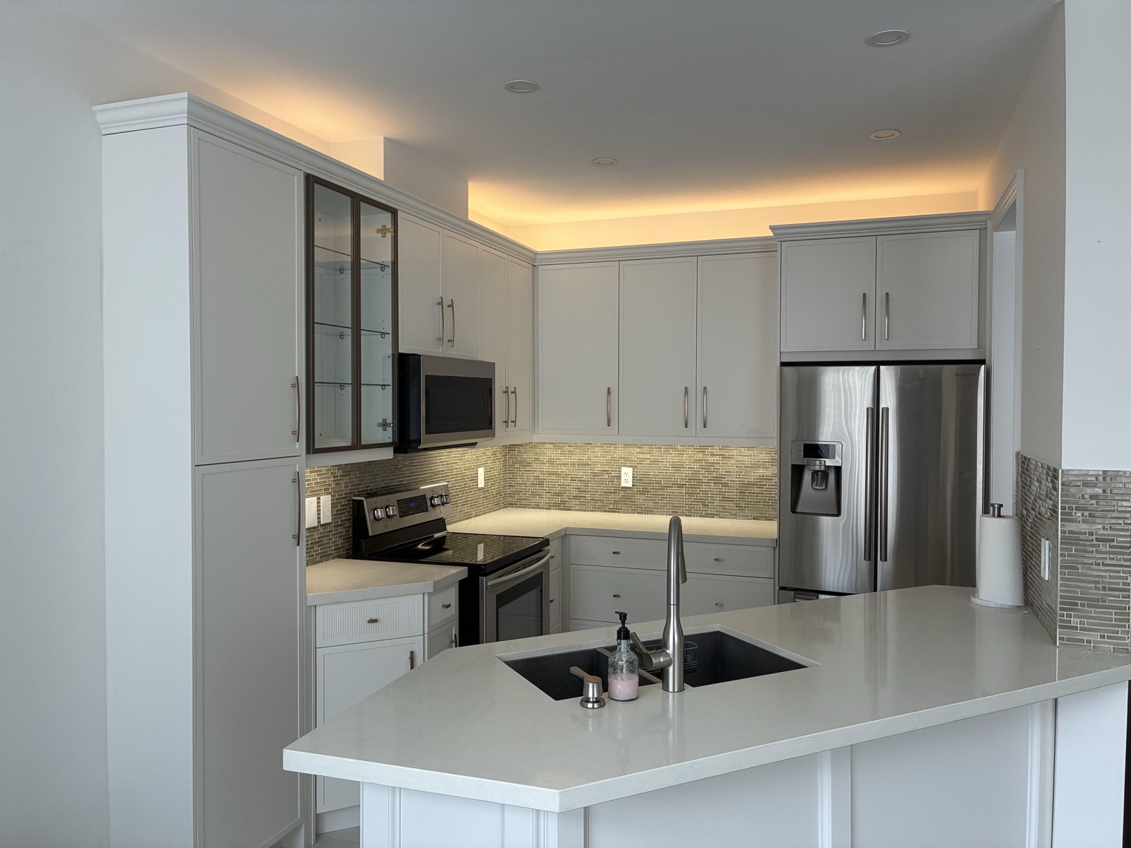 Renovated Toronto kitchen combining under-cabinet task lighting with perimeter cove lighting
