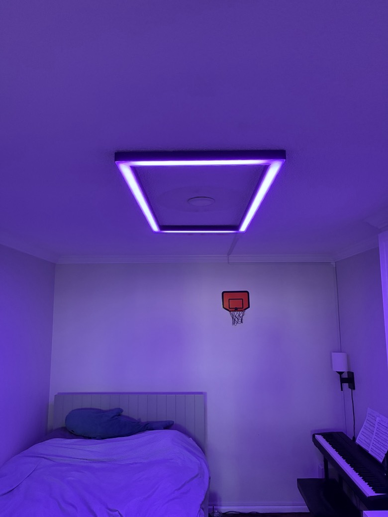 Custom RGB LED ceiling fixture glowing purple in a windowless bedroom